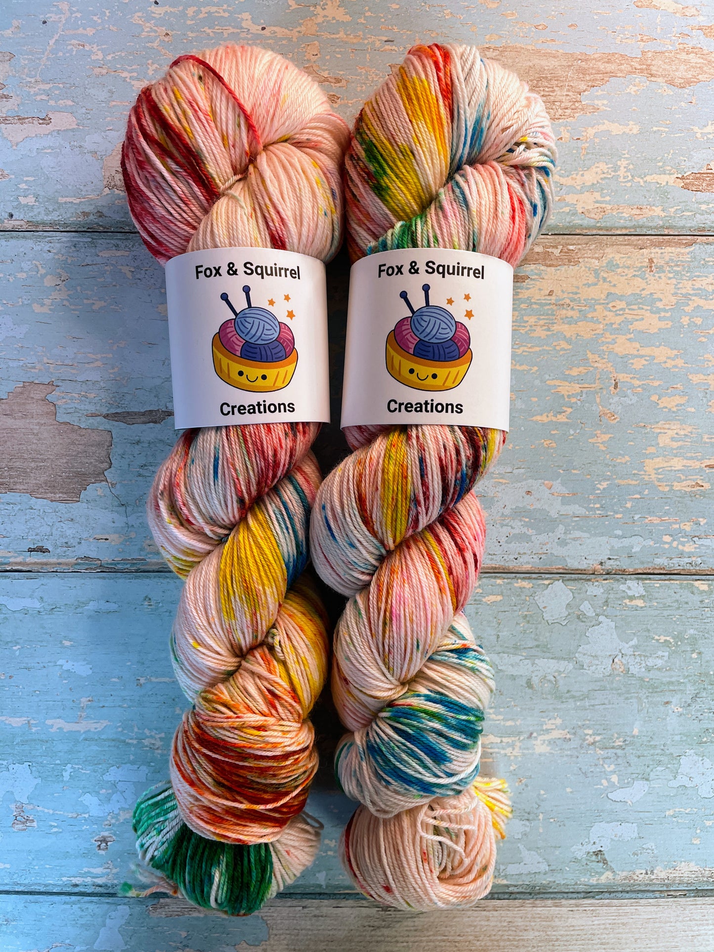 Zoomed in shot of 100g Sock weight yarn in colourway Rainbow Sprinkles. This is an undeyd yarn base with layers of speckles in red, yellow, green, blue.