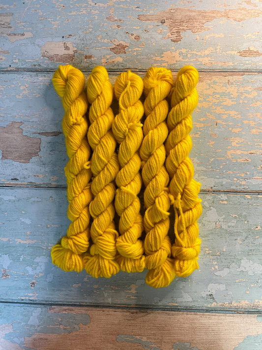 Full shot of DK weight mini skeins in the colourway Sunshine. This semi-solid colourway in shade Bright Yellow.