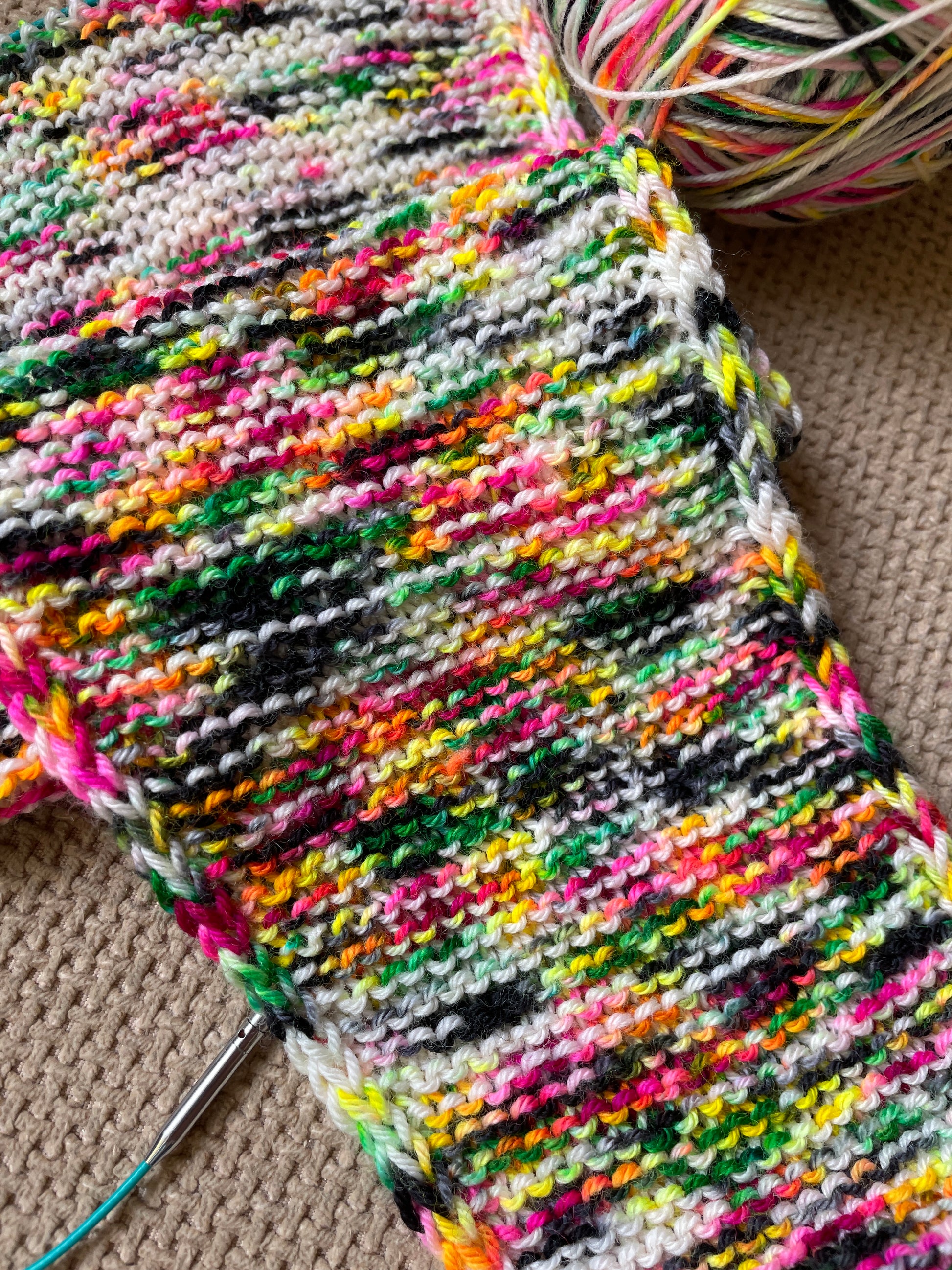 A knitted sample using 100g of Sock weight Punk Rocker. The knitting pattern is a large Sophie Scarf.