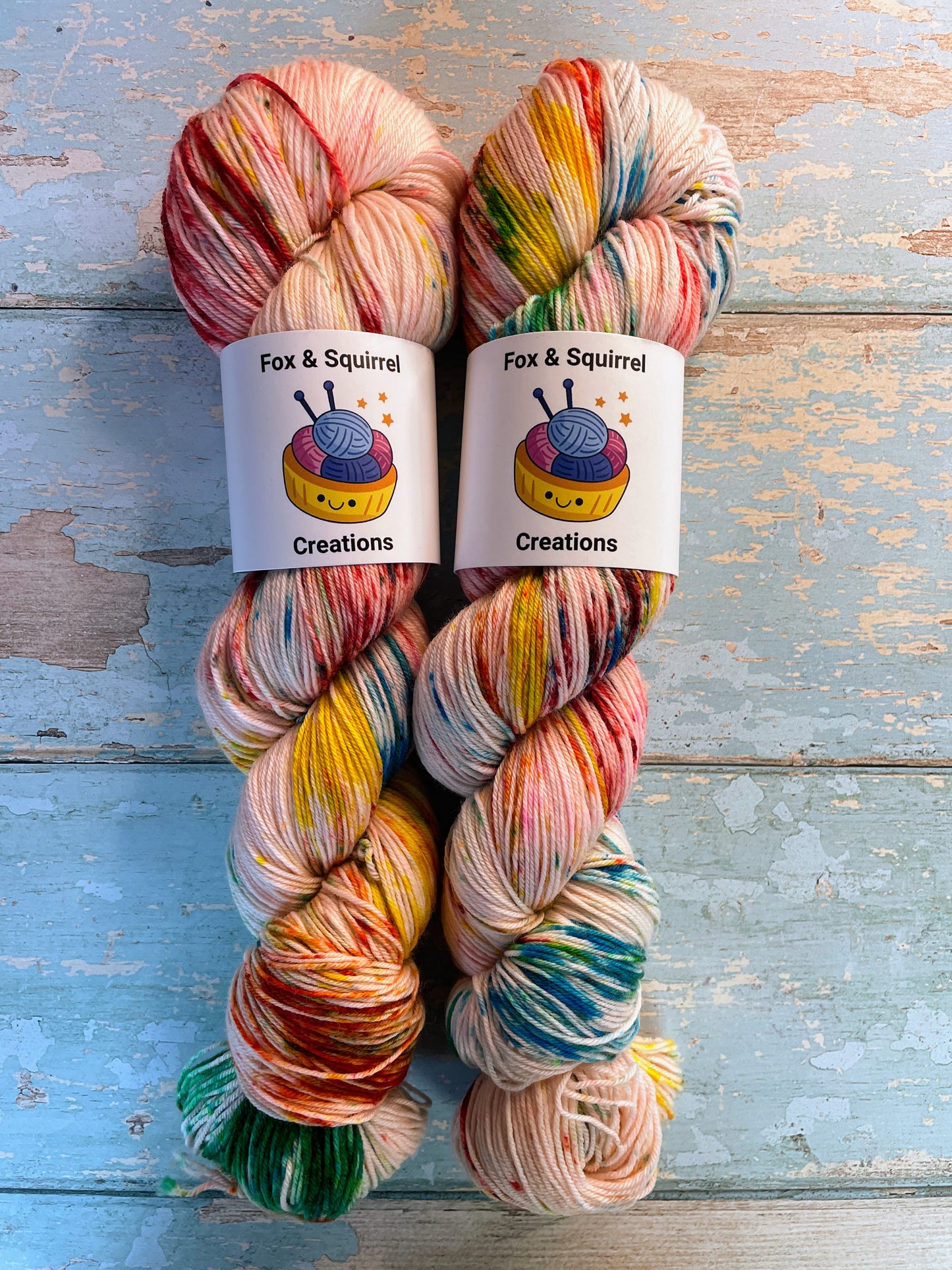 Zoomed in shot of 100g Sock weight yarn in colourway Rainbow Sprinkles. This is an undeyd yarn base with layers of speckles in red, yellow, green, blue. 