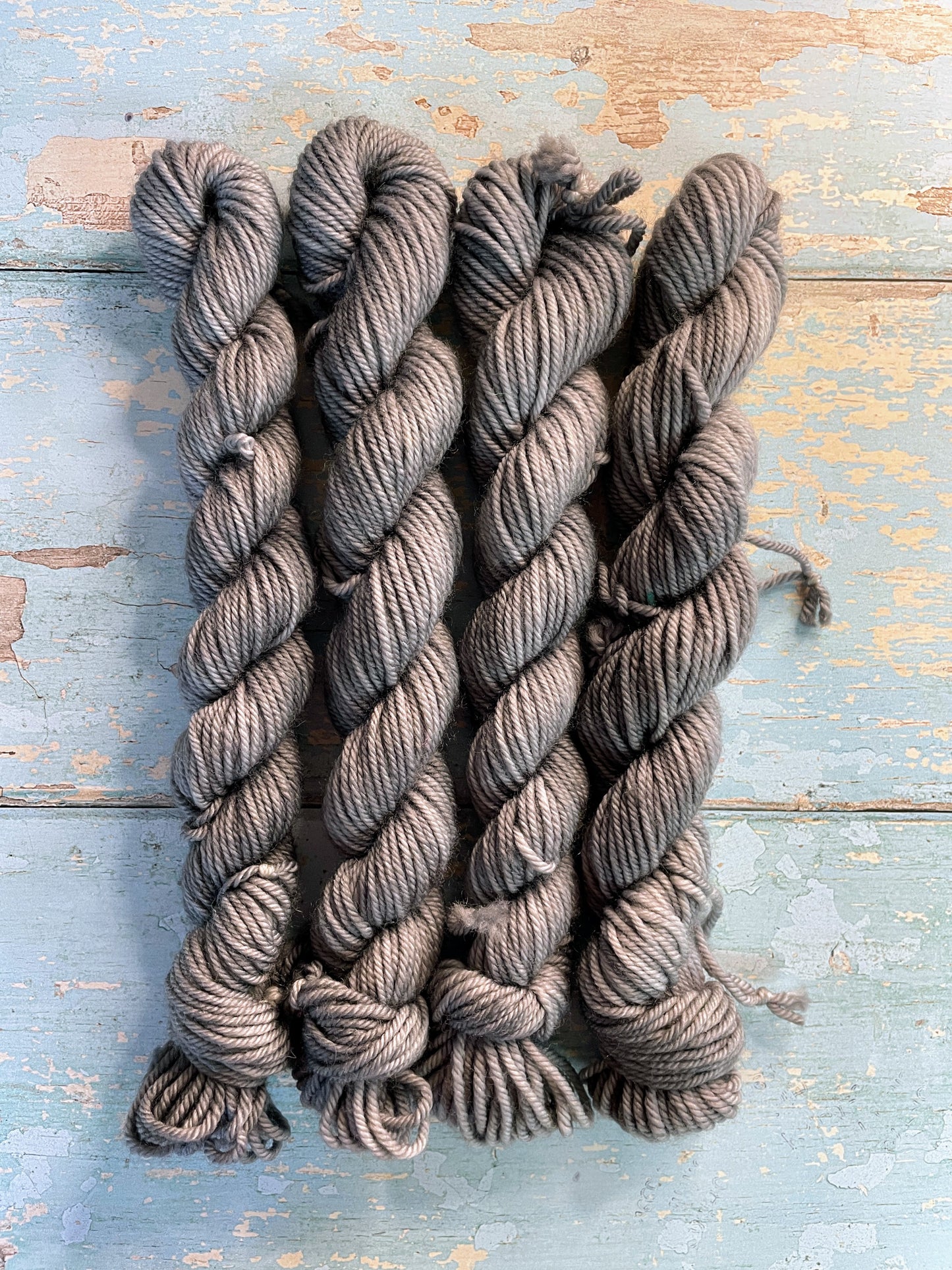 Zoomed in shot of 20g DK weight mini skeins in semi-solid colourway Grey. This colourway is a rich silver, grey colour.