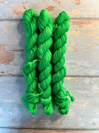 Full shot of 20g DK mini skeins in colourway Neon Green. This is a semi-solid colourway and will glow under U.V. light.