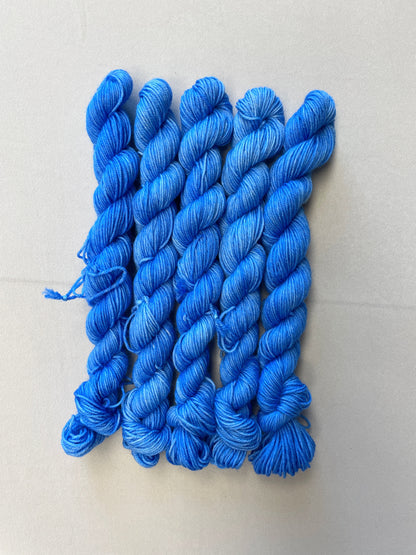 Zoomed in shot of 20g sock weight mini skeins in the semi-solid colourway Intense Blue. This colourway is a light blue colour. 