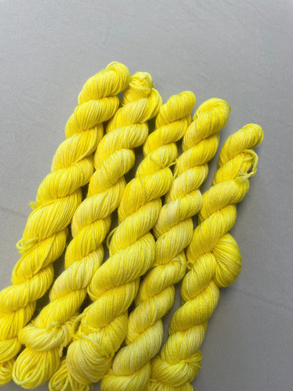 Close up shot of 20g Sock weight mini skeins in colourway Lemon. A semi-solid colourway of pale yellow colour. 