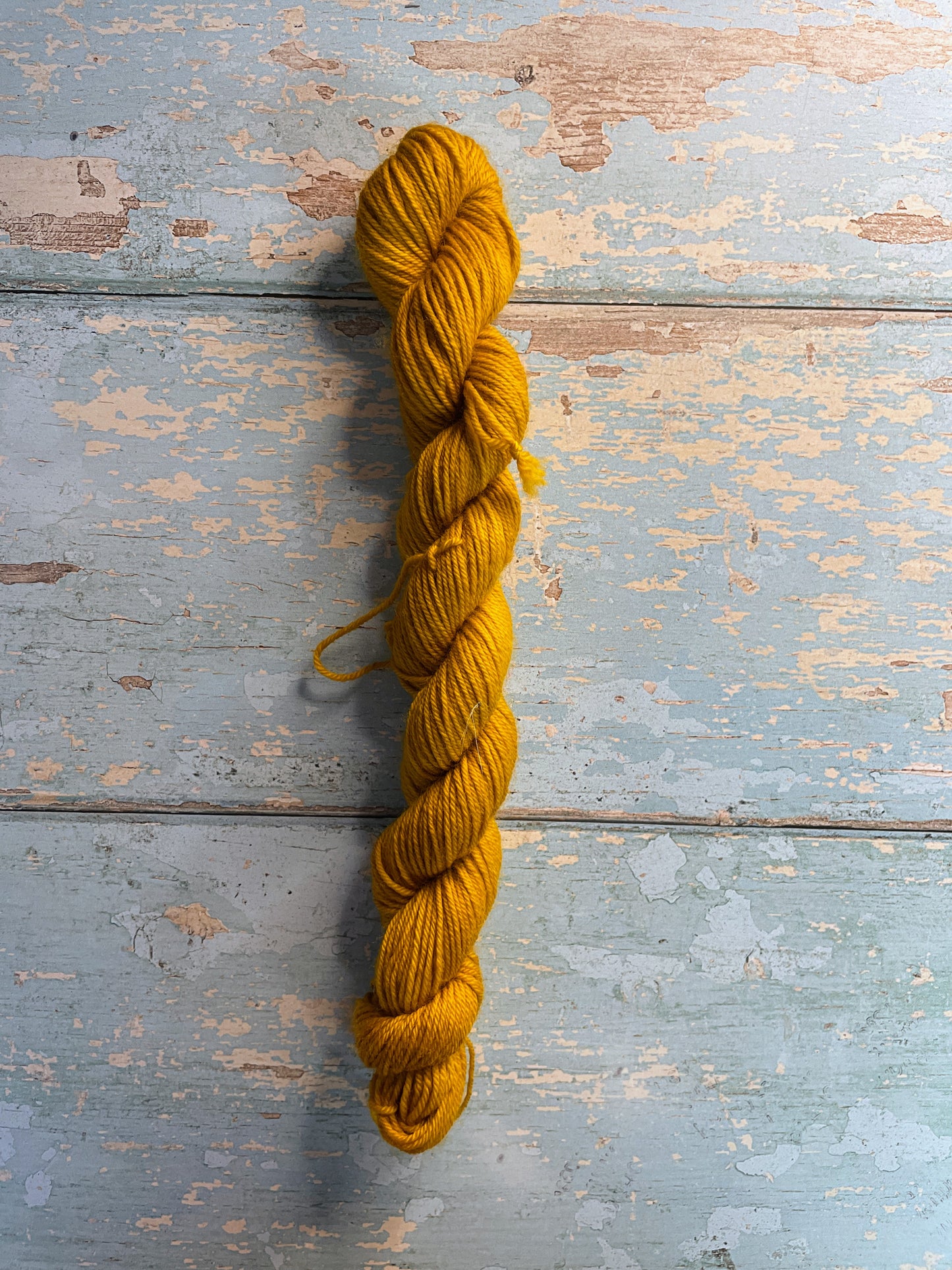 Full shot of Sock weight mini skeins in colourway Mustard. This is a semi-solid colourway in a rich, golden mustard colour.