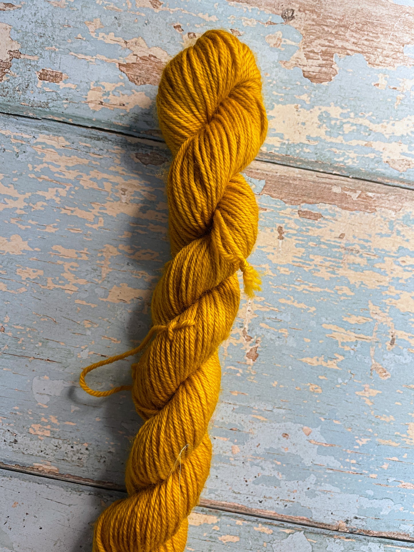 Close up shot of Sock weight mini skeins in colourway Mustard. This is a semi-solid colourway in a rich, golden mustard colour.