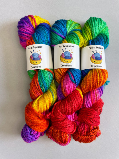 3 skeins of Hand-dyed Yarn in colourway Bright Rainbow on our Chunky Yarn Base. The yarn is 100% merino wool. The yarn contains 7 bright colours, sunshine, lava, ruby, apple, cyan, electric purple and neon pink and photographed on a white background.